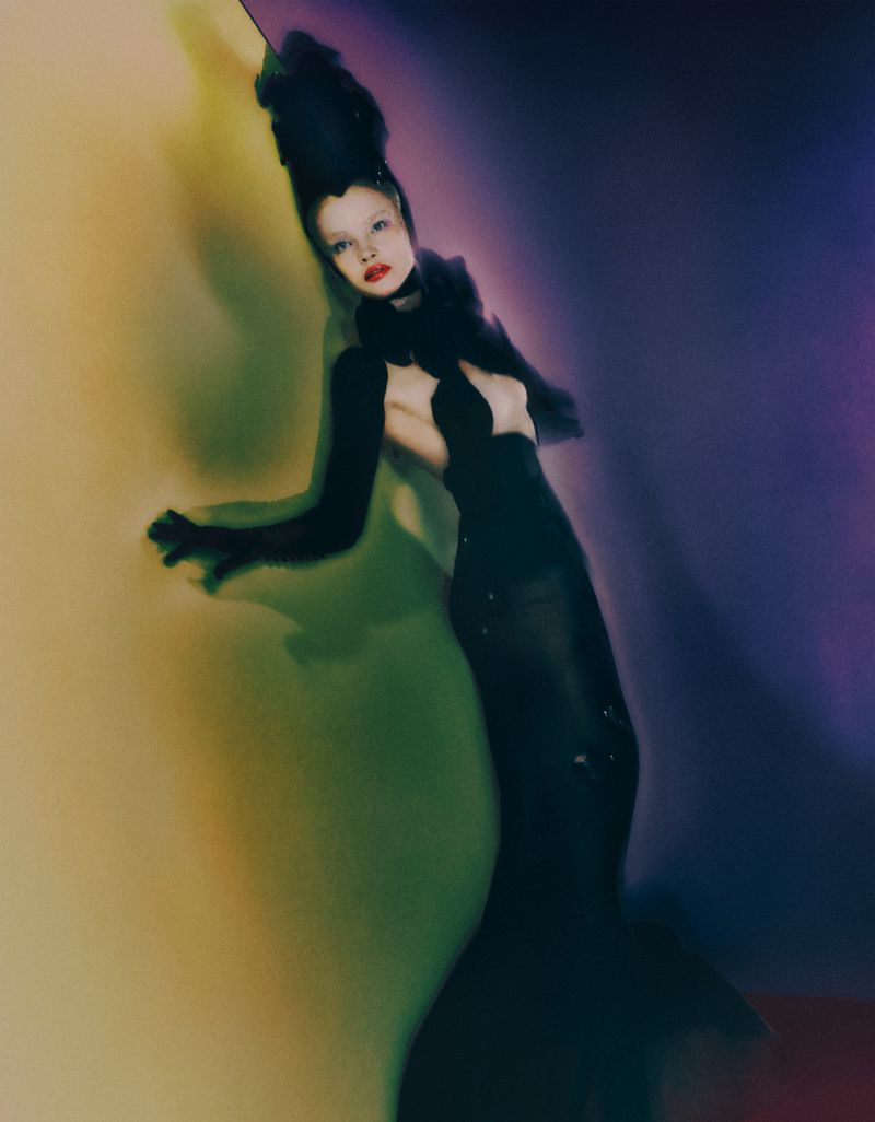 Natalia Vodianova in a black evening gown for Ulyana Sergeenko haute couture against a gradient background.