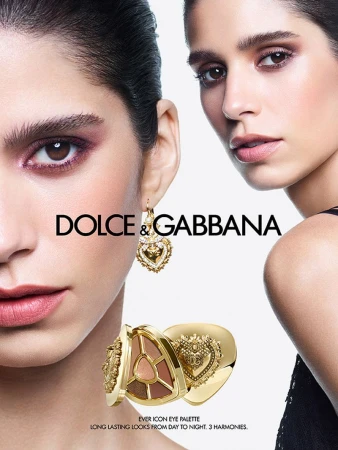 Cosmetics advertising featuring two women with professional makeup wearing golden earrings, with Dolce & Gabbana brand logo and eye palette.