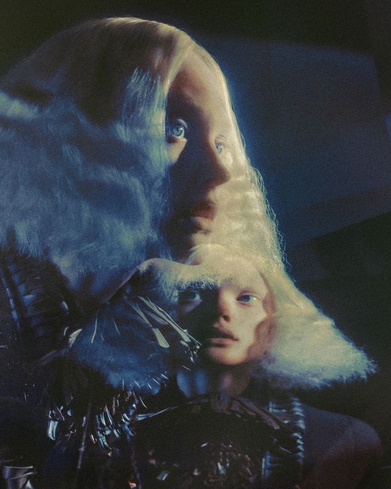 Surreal portrait of two women with blonde hair, one in profile and one facing forward, dark background, fashion, beauty, portrait.