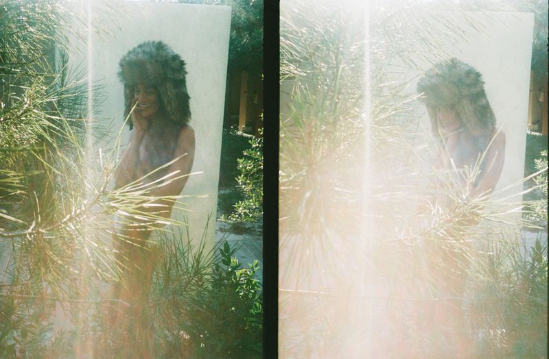 Woman in a fur hat poses behind blurred greenery in a diptych featuring lens flares, natural light, and a neutral backdrop.