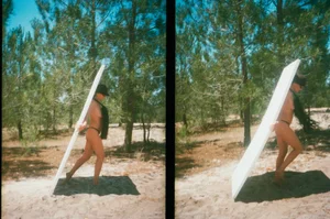 Model carrying a large white panel through a sunlit pine forest for a Purple Magazine editorial by Mark Borthwick