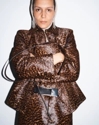 Model in leopard print jacket holding a handbag against a plain white background for beaufille
