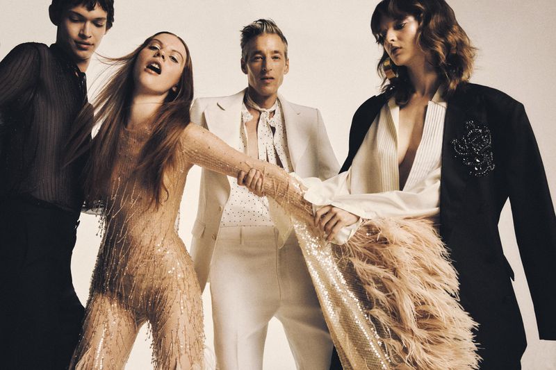 Group fashion shot: Four models showcase diverse outfits in a studio setting, featuring a mix of textures, colors, and styles on a white backdrop.