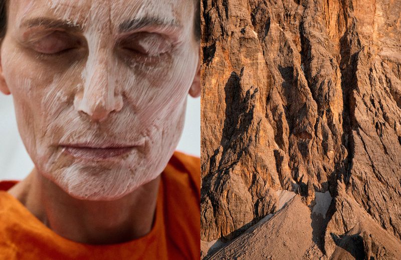 Older woman with facial mask next to mountain peak. Beauty treatment contrast with nature's raw beauty, warm color palette.