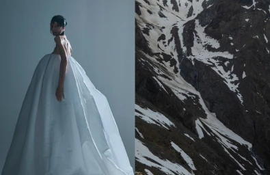 Model in a voluminous white gown standing against a neutral studio backdrop beside a panel showing a snowy mountain terrain