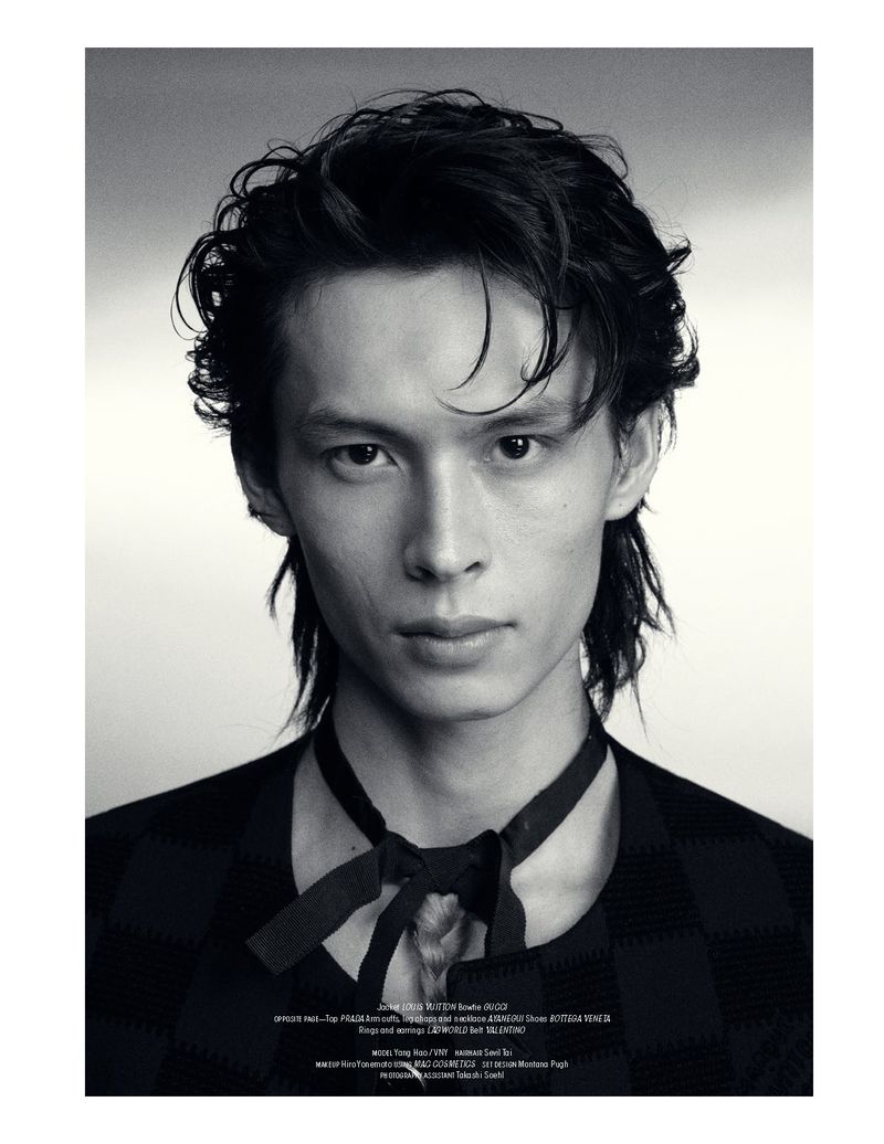 Black and white studio portrait of model Yang Hao wearing a dark patterned top with a tied ribbon collar.