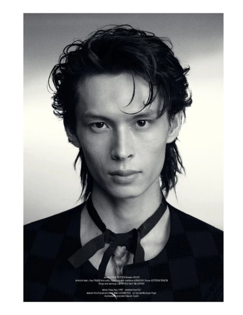 Black and white studio portrait of model Yang Hao wearing a dark patterned top with a tied ribbon collar.