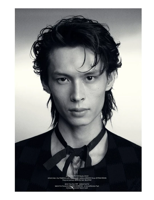 Black and white studio portrait of model Yang Hao wearing a dark patterned top with a tied ribbon collar.