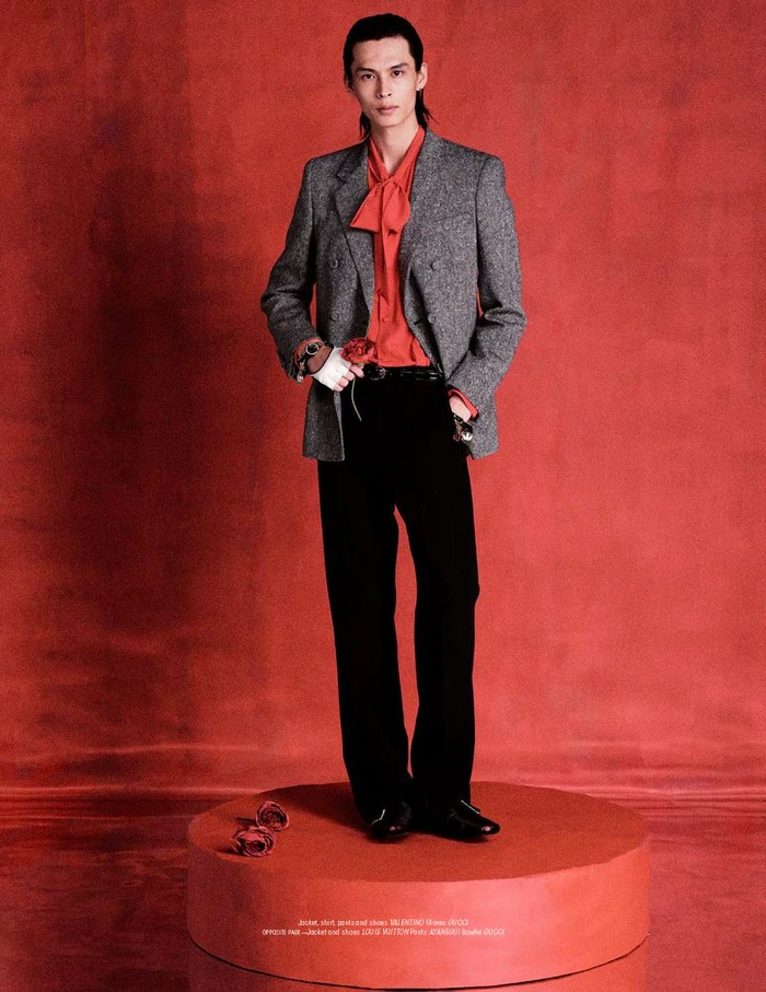 Model Yang Hao wearing grey blazer and black trousers standing on red platform for L'Officiel Malaysia editorial