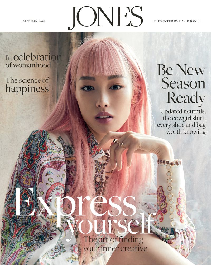 Magazine cover featuring a young woman with pink hair and a patterned top, with text overlays for brand and cover story highlights.