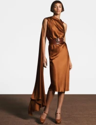 Model in brown silk dress with matching belt and long drape standing against a white backdrop for Max Mara FW25