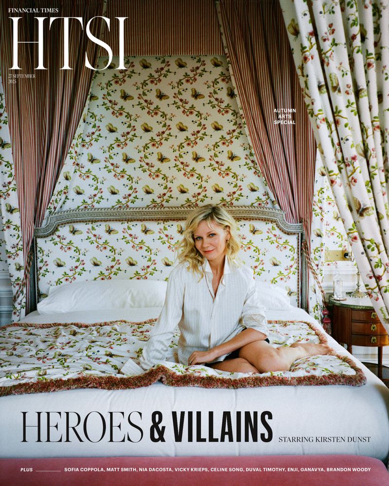 Kirsten Dunst poses on a floral-patterned bed for a magazine cover with light, soft lighting, creating an inviting, relaxed, celebrity portrait.