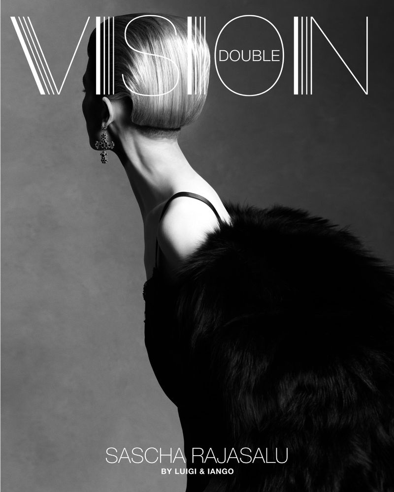 Fashion magazine cover in black and white featuring an adult female model with a blonde bob, wearing a fur coat and earrings.