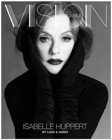 Black-and-white portrait of Isabelle Huppert in gloves, featuring dramatic dark lipstick, in front of a plain gray backdrop, editorial in style.
