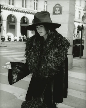 Renate Reinsve wearing a wide-brimmed black hat and feather coat on a city street for Mastermind Magazine