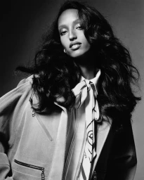 Model Mona Tougaard in a collared shirt with patterned necktie against a plain grey backdrop for Harper's Bazaar