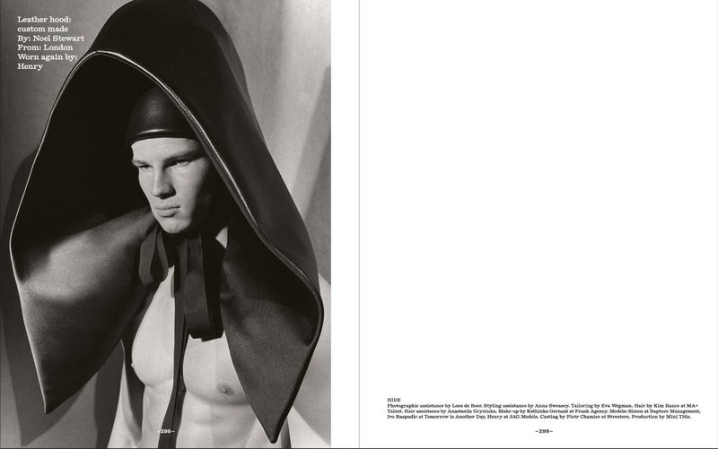 Monochrome fashion shot of a male model wearing a custom-made leather hood with a tie, showcasing editorial photography in a studio setting.
