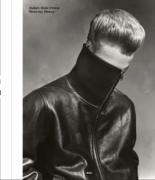 Black and white editorial portrait of male model in a high-collared Rick Owens leather jacket covering the lower half of his face.