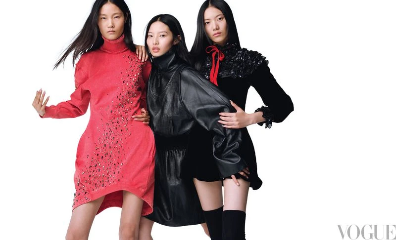 Three Asian fashion models pose in dresses against a white background. The dresses are coral, black leather and black velvet.