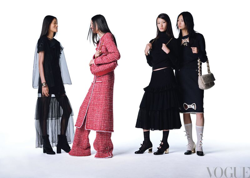 Four Asian female fashion models pose against a white backdrop, showcasing modern apparel. Two wear all-black outfits, two in red.