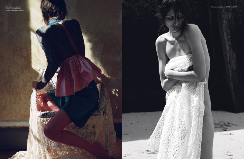 Two women pose in a fashion editorial; one is wearing an artfully-draped dress, the other is partially covered in a textured shawl outdoors.