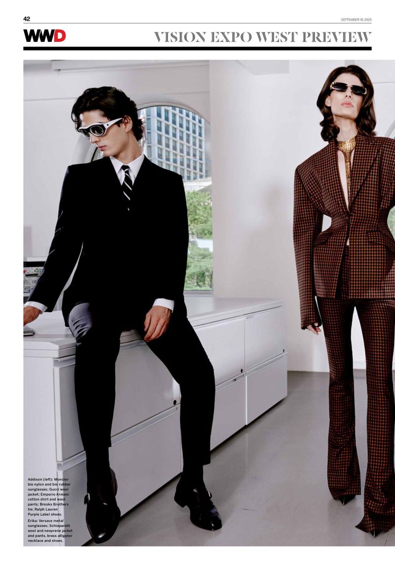 Two fashion models showcase tailored suits and sunglasses indoors, embodying a modern, sophisticated aesthetic with architectural details in the background.