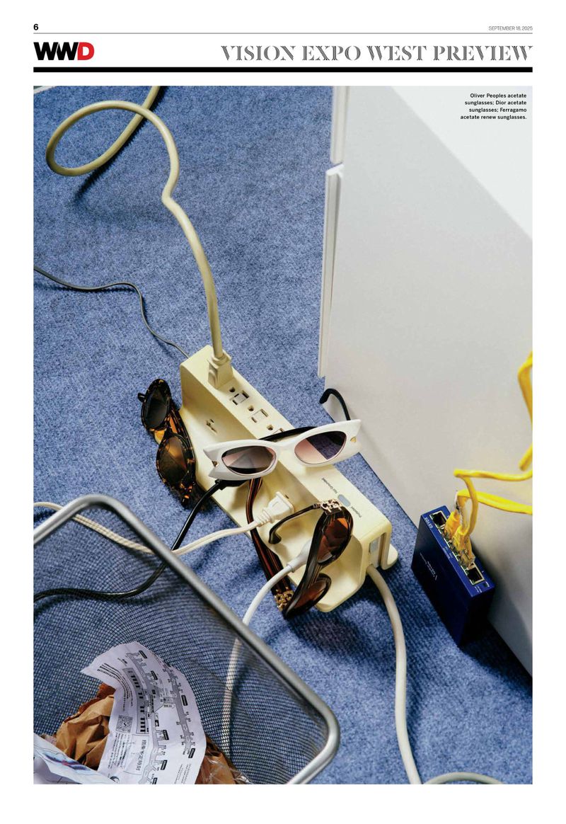 Indoor shot featuring sunglasses on a power strip with cords, and a blue textured surface, evoking a tech and fashion crossover.