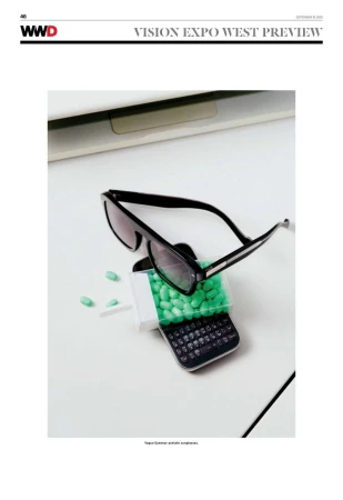 Sunglasses rest on top of a vintage phone filled with green candy, all set against a clean white background, evoking a sense of retro-cool.