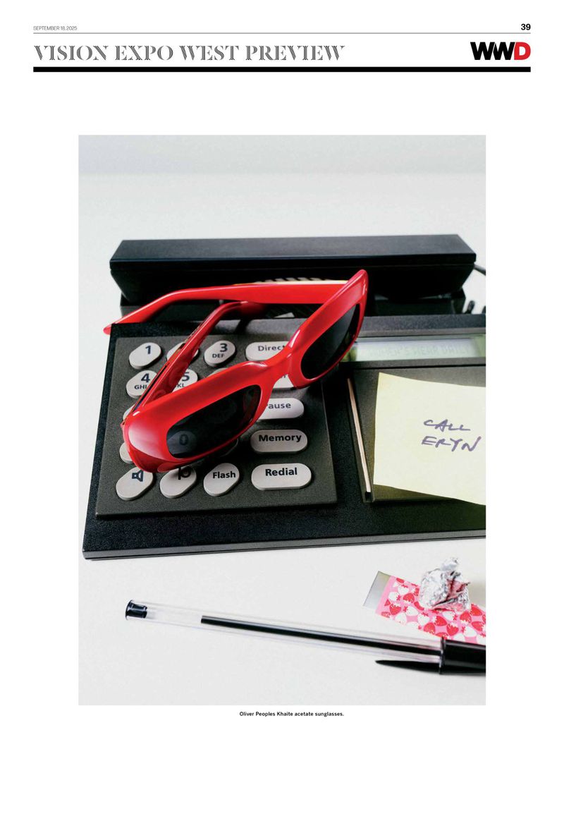 Red sunglasses are displayed on a retro landline phone along with a pen, crumpled paper, and a sticky note. WWD brand logo visible.