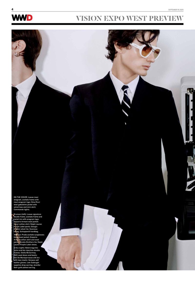 Two men in dark suits, one wearing sunglasses, standing next to a printer. Fashion editorial, modern vintage style, studio lighting.