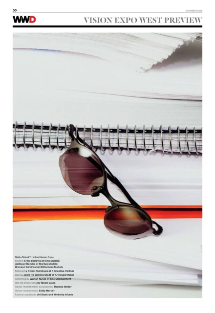 Fashion magazine product shot featuring sunglasses and a stack of papers and a notebook. The image has a editorial feel.