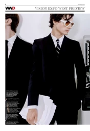A male model in a black tailored suit and white-framed sunglasses holding sheets of paper alongside another model in a suit.