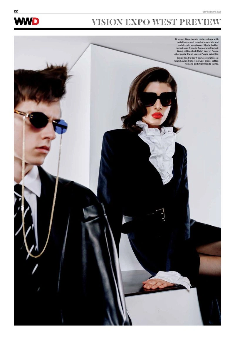 A man and woman wearing designer sunglasses and formal black-and-white tailoring in a bright architectural studio setting.