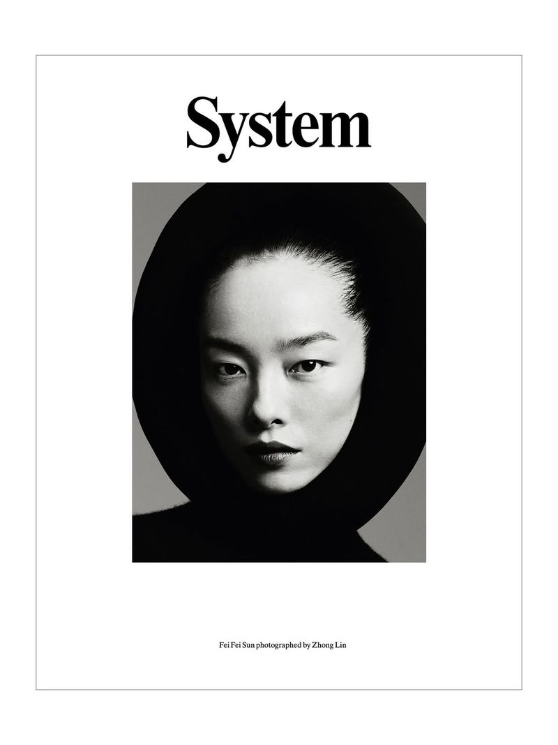 Black-and-white portrait of Fei Fei Sun on a magazine cover, gazing forward with a neutral expression, wearing a black turtleneck and hat.