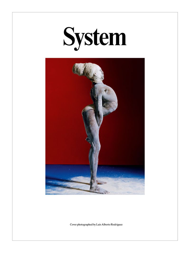 Magazine cover featuring an artistic nude female figure, photographed by Luis Alberto Rodriguez, with a red background and white floor.