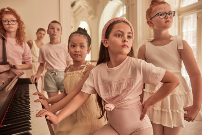 Group of children gathered around an upright piano in an ornate room for the Live With Us project by Justin Woo.