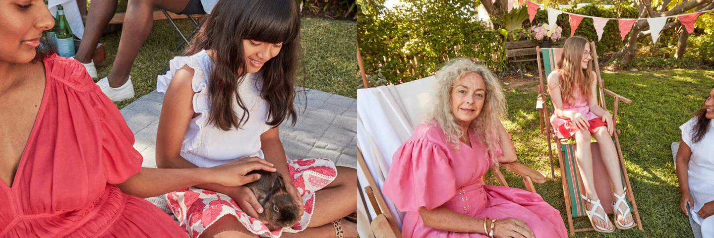 Outdoor gathering of women and a girl in dresses enjoying time together on a sunny day with a pet rabbit on a patterned blanket.
