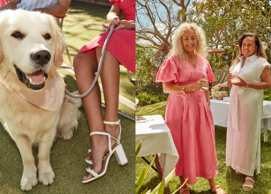 Golden Retriever dog wears bandana at outdoor social event with two adult women in dresses and sandals enjoying daytime garden party.