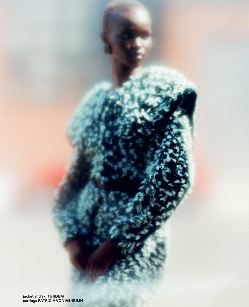Model Adau Aguer posing in a textured bouclé jacket and skirt in a soft-focus fashion editorial for Autre Magazine.