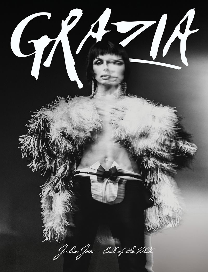 Black and white fashion magazine cover featuring Julia Fox wearing a feathered jacket and trousers with a blurred effect and bold typography.
