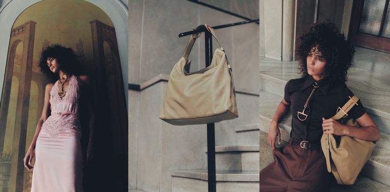 Fashion shot of a model wearing a brown collared shirt and tan purse sitting on marble stairs next to a model in a flowing pink dress.