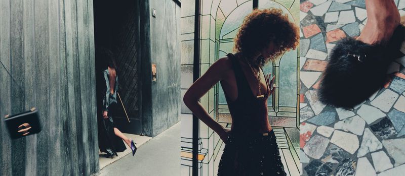 Fashionable woman in backless dress walking through a doorway with a black purse, alongside a curly-haired woman in a dress.