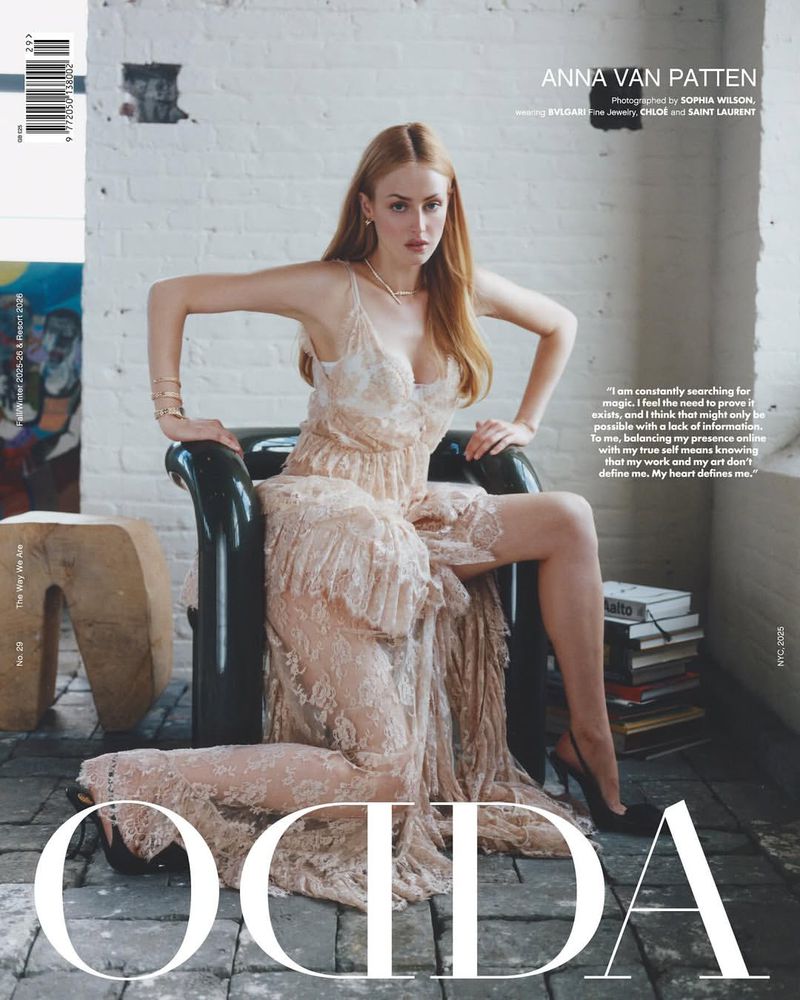 Magazine cover featuring Anna van Patten in a champagne-colored lace dress, seated on a black chair against a white brick wall backdrop.