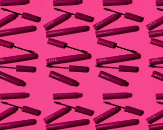 Patterned flat lay of Rye Beauty magenta tinted brow milk tubes and mascara wands on a bright pink background.