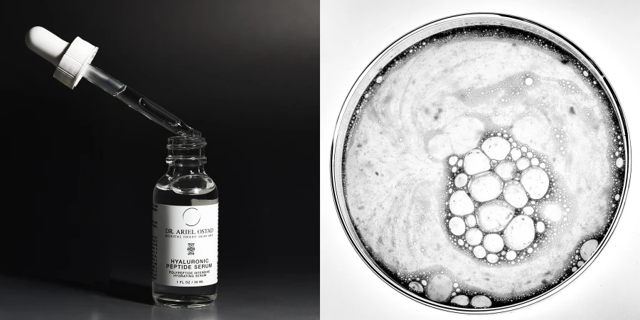 Cosmetic serum bottle with dropper on a black surface. A petri dish with serum liquid is to the right, showcasing product.