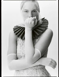 Model wearing a sheer veil, ruff collar, and long gloves posing for Mixte Runaway Bride editorial