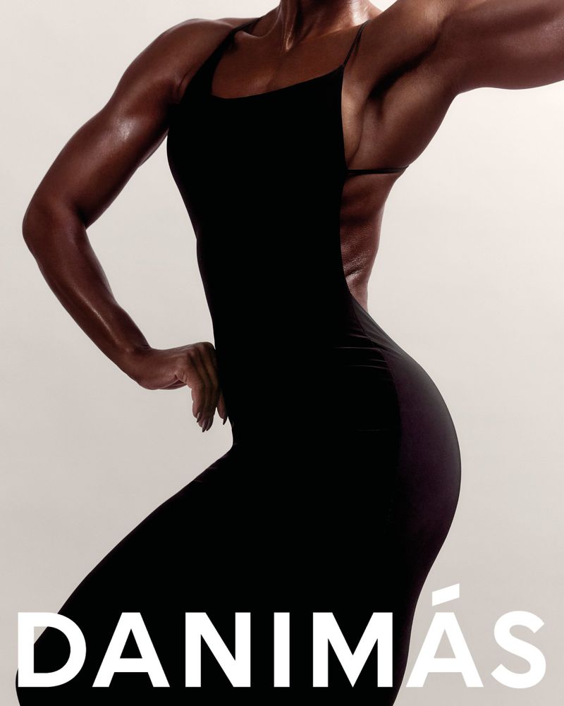 Muscular woman wearing a fitted black dress against a plain neutral background with bold white typography at the bottom.