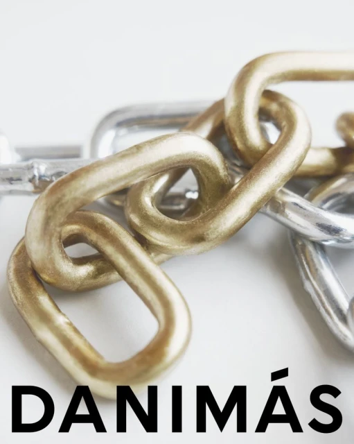 Close-up of interlocked gold and silver metal chains on a clean white surface, emphasizing their texture and connection.