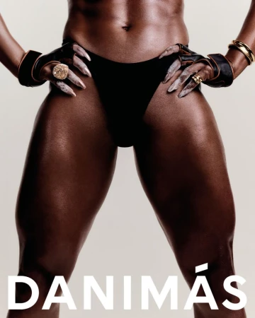 Close-up studio shot of an adult female with dark skin wearing a black swimsuit bottom and gold jewellery. Muscular thighs are in focus.