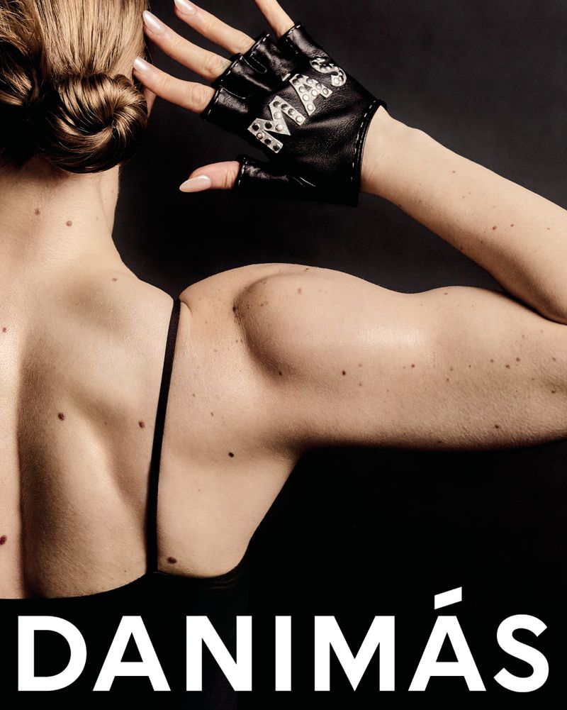 A woman's back and upper arm with a black fingerless glove on her hand is displayed on a black background with a text overlay.